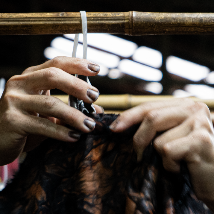 Craftsman's hands tying leather by hand
