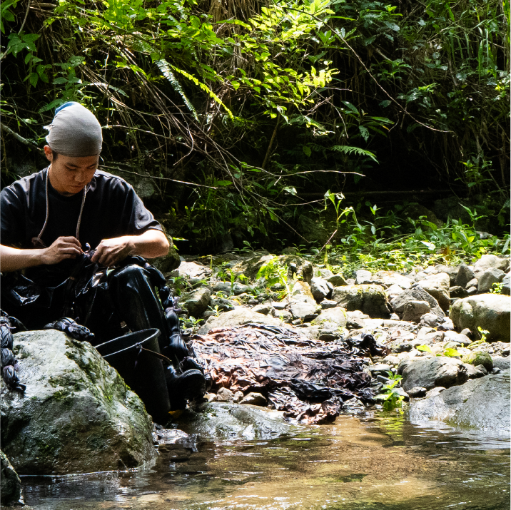 Craftsman processing leather by the riverside