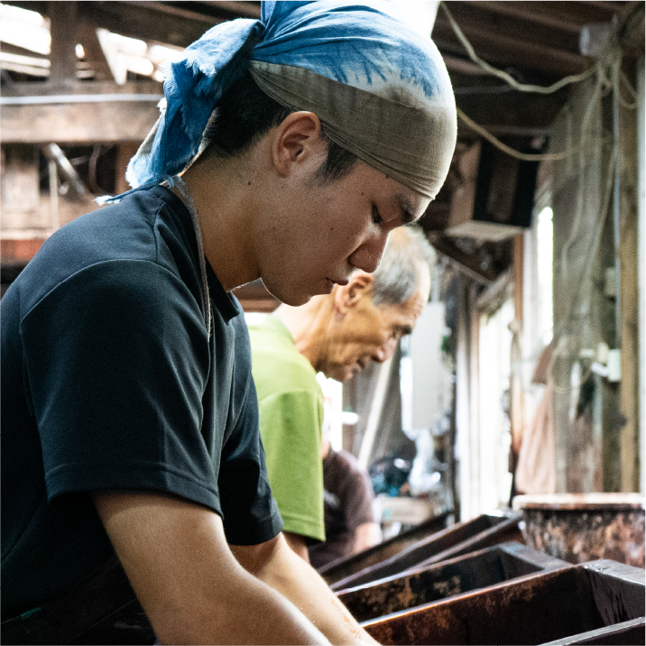 Craftsman focused on leather dyeing process in workshop